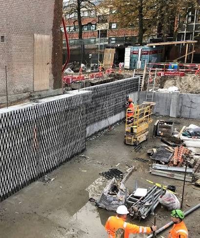 Drainage mesh installation along a basement retaining wall